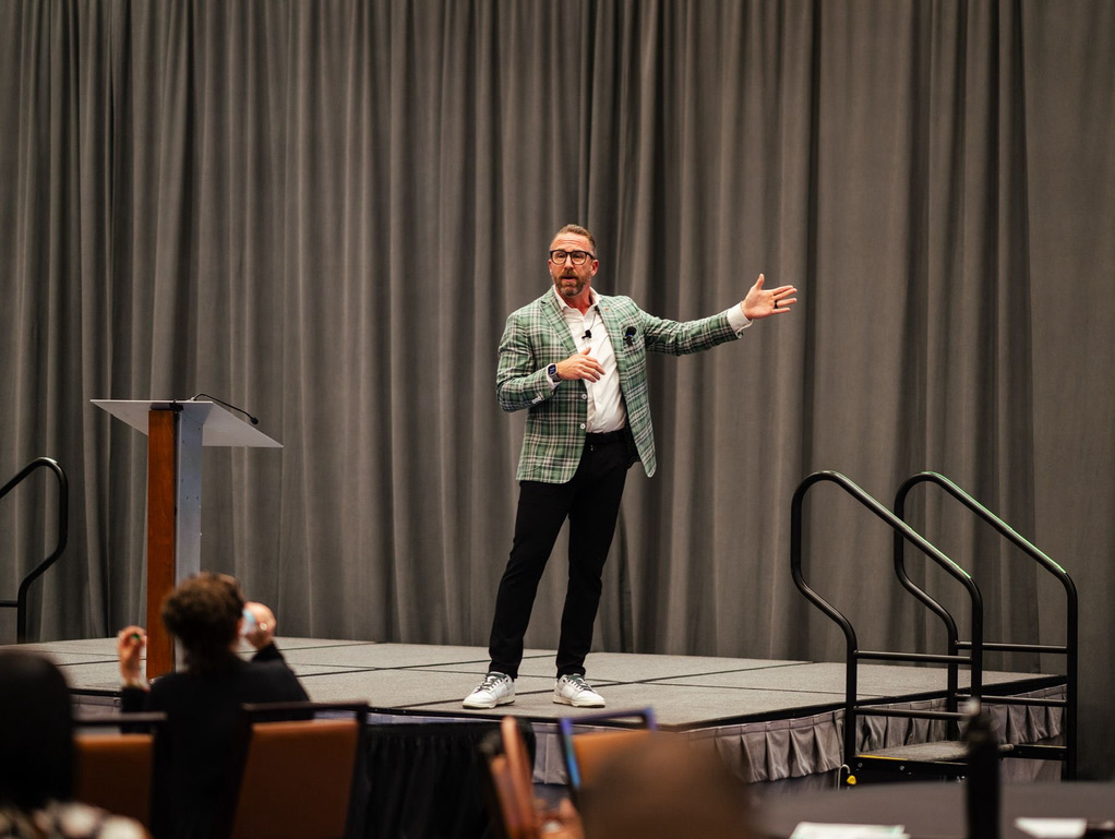 Ryan Miller speaking on stage at a Men of Greatness event